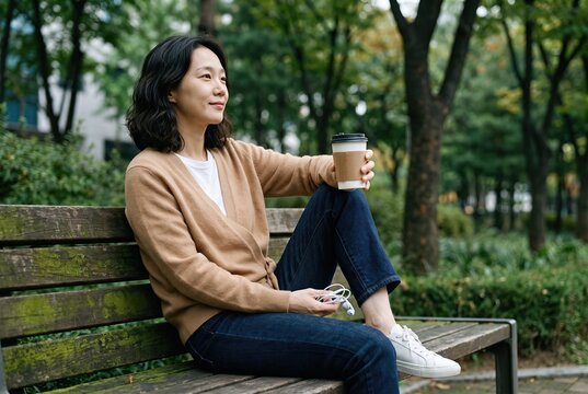Generative AI, Asian woman relaxing with coffee on a park bench outdoors 