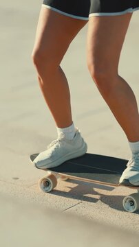 Young athletic woman longboarding in the summer sun