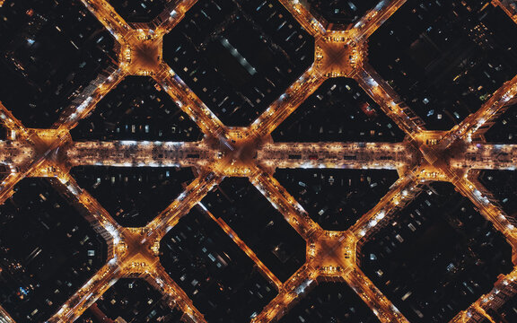 Aerial view of the Eixample district at night, showcasing the iconic grid pattern of octagonal city blocks illuminated by streetlights Barcelona, Catalonia, Spain.
