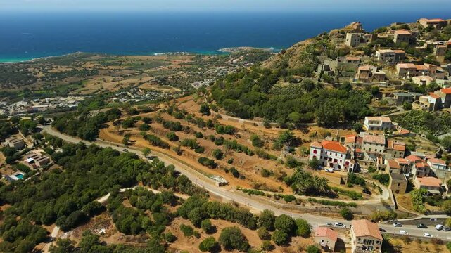 Corbara Corsica France aerial drone cascaded houses authentic village sea view traditional stone town Balagne region travel destination 4k video