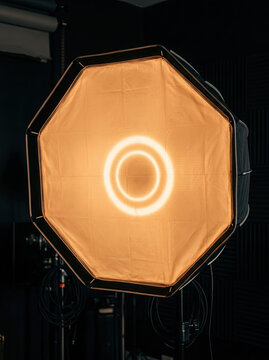Bright octagonal softbox light illuminating dark studio space, creating warm ambiance