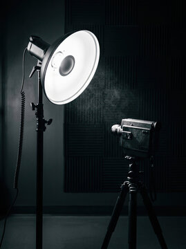 Studio lighting setup with softbox and camera on tripod, creating professional atmosphere