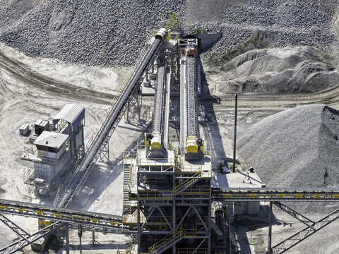 Aerial view of the limestone crushing and screening plant at Vulcan River Road Asphalt Plant with industrial conveyor belts and piles of crushed stone in Nashville, Tennessee, United States.