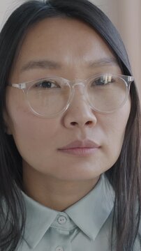 Close-up slow motion portrait of elegant Asian businesswoman looking at camera against luxury house background. People and individual style concept.