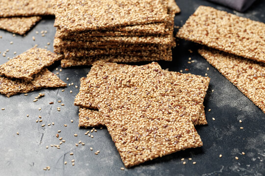 Wholegrain Crispbread with Sesame and Flax Seeds on Dark Surface