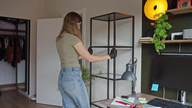 Woman placing shelving unit beside home office desk