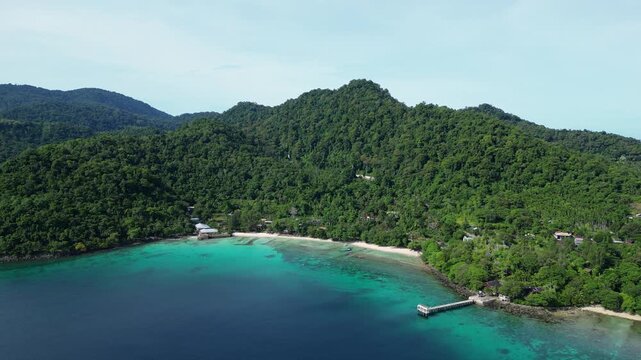 Weh Island, Indonesia : Aerial drone footage Gapang white sand beach in Weh Island of Sabang in Aceh, Indonesia with ocean reef, taken with orbit motion showing jetty and tropical rain forest