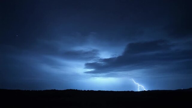 A dark night sky illuminated by soft diffuse heat lightning flickering silently between distant clouds.