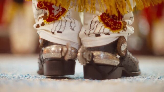 Ornate boots and ankle decorations heel click in traditional Moors dance during Angahuan ritual