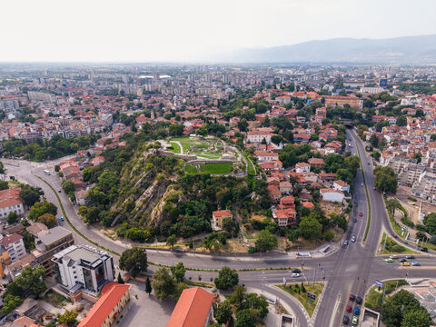 Aerial view of the historic Nebet Tepe archaeological site surrounded by the urban landscape, red-tiled rooftops, and winding roads of Plovdiv, Plovdiv, Bulgaria.
