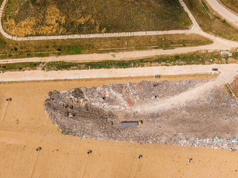 Aerial view of a large landfill site with heavy machinery and a truck operating on piles of waste in Varna, Varna, Bulgaria.