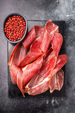 Sliced prsut prshut, Balkan cured pork meat ham. black background. top view