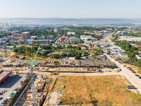 Aerial view of a large construction site with multiple cranes and ongoing building works in the urban landscape of Varna, Varna, Bulgaria.