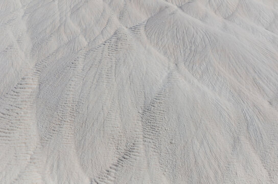 Natural white travertine texture at Pamukkale, Turkey, featuring mineral terraces and unique geological patterns.