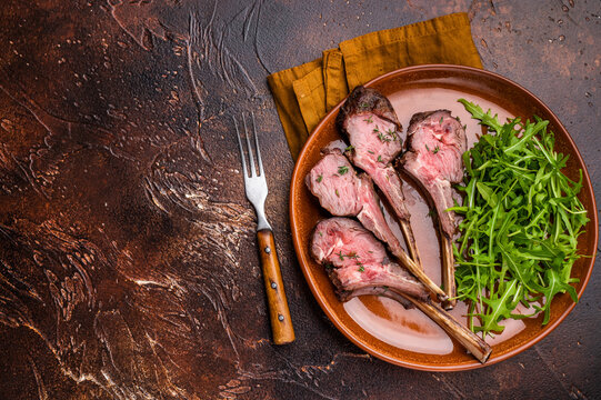 Roasted lamb chop cutlets, mutton meat steaks  with salad. brown background. top view