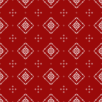 Red and white geometric textile pattern featuring repeating diamond motifs with intricate folk-inspired details and small cross-shaped accents arranged in a balanced grid.