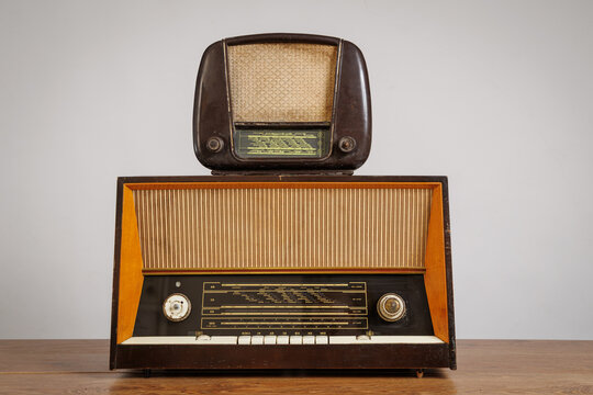 Two Vintage Retro Radios Stacked on a Wooden Table. Antique Multi-band Radio Receivers. Soviet-Era Broadcast Devices