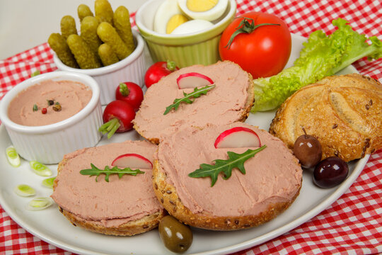 Rustic Breakfast Plate with Pate Sandwiches, Radish, Pickles, Boiled Eggs, Olives, and Fresh Vegetables. Hearty Breakfast or Appetizer Platter