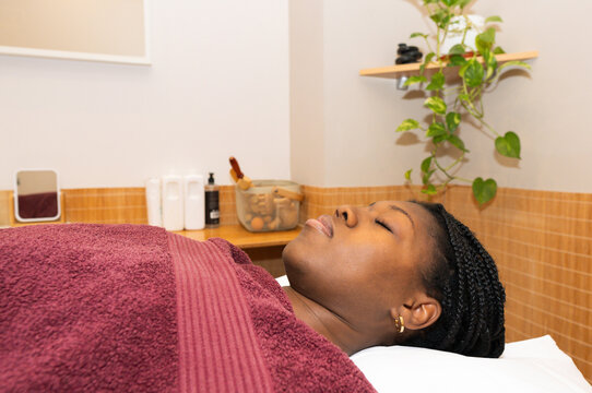 Black woman resting peacefully on a massage table in a spa