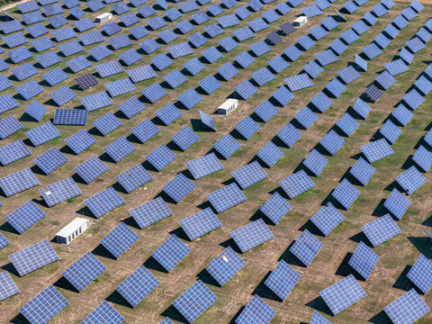 Aerial view of a large-scale solar panel system installed in an open field, showcasing rows of photovoltaic panels arranged for renewable energy generation in Spinetta Marengo, Piedmont, Italy.