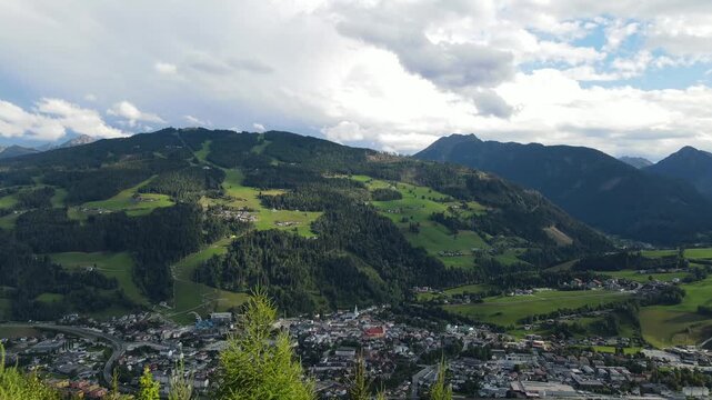 Aerial drone view of Planai mountain and the town of Schladming in the Austrian Alps. The alpine landscape while dark storm clouds gather over the mountains creating a dramatic atmosphere