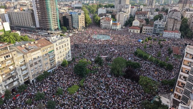 Aerial view of Slavija square filled with a large crowd of people during a public gathering, surrounded by urban buildings and city streets in Beograd, Grad Beograd, Serbia.