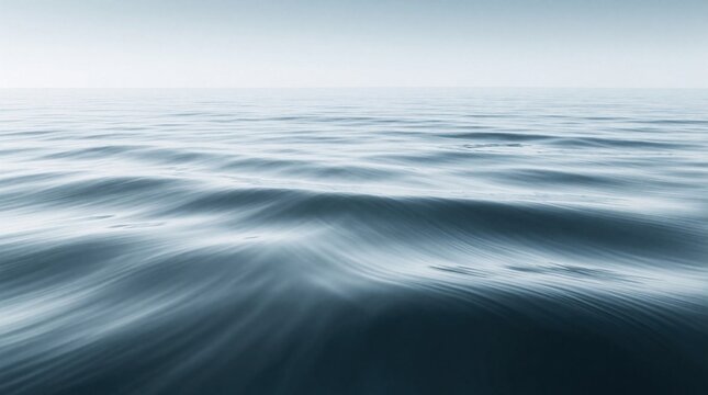 Minimalist ocean surface with soft wave patterns. Peaceful blue water, horizontal lines, and tranquil atmosphere create a serene seascape for calm backgrounds.