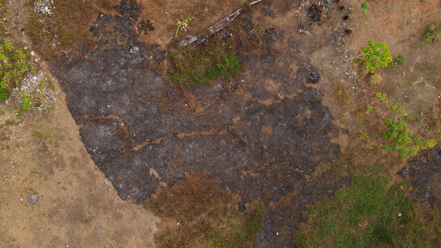 Aerial view of Waisai showing charred ground and patches of vegetation after land clearing in Raja Ampat, Southwest Papua, Indonesia.