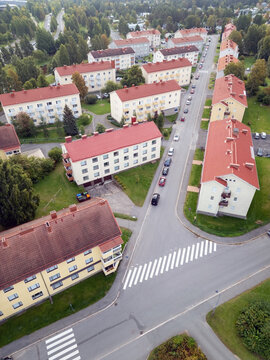 Aerial view of the Karjasilta residential district featuring apartment buildings with red roofs, tree-lined streets, and pedestrian crossings in Oulu, North Ostrobothnia, Finland.