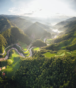 Aerial view of Kim Noi Viewpoint featuring lush green terraced rice fields, a winding river, and dense forest-covered mountains in Mu Cang Chai, Lao Cai, Vietnam.