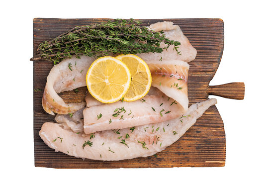 Haddock sea fish fillets, raw whitefish on a wooden board ready for cooking isolated on white background. top view