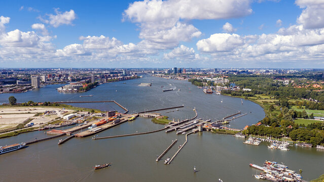 Aerial view of Oranjesluizen complex with its historic locks, surrounding waterways, and boats navigating the IJ river in Amsterdam, Noord-Holland, Netherlands.