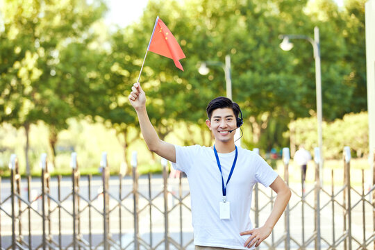 Smiling tour guide holding Chinese flag outdoors