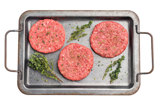 Raw hamburger minced meat patties  for burgers with herbs on tray isolated on white background