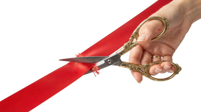 Hand using gold scissors cutting a long red ribbon for grand opening isolated on transparent background