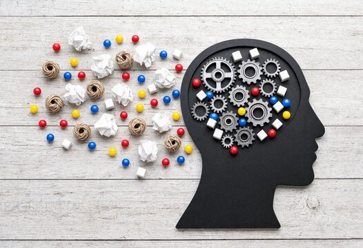 Conceptual flat lay of a human head silhouette with gears and creative chaos representing intellectual process and creative thinking