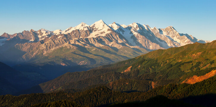 Panorama of Caucasus mountains. Fantastic summer scene of snovy peaks in the mist, Upper Svaneti, Georgia. Beauty of nature concept background