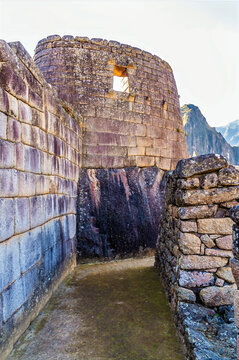 A view down the side of the Temple of the Sun built atop a large natural rock outcrop at Machu Picchu in Peru in the dry season