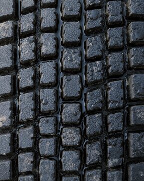 Rubber texture with a deep tread pattern, featuring water beading on a dark charcoal vulcanised surface for automotive and industrial backgrounds