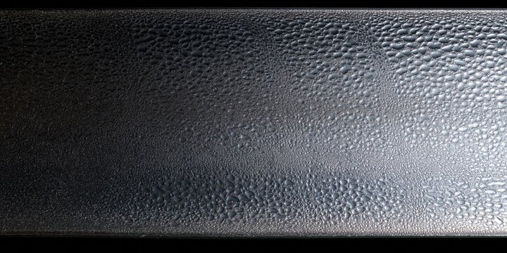 Condensation beads on cold clear glass with running water trails and a dark grey background for beverage and cosmetics design