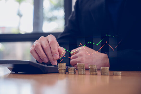 Businessman using calculator and stacking of coins for Financial and investment concept