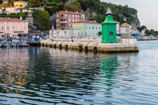 Piran Slovenia harbor with green lighthouse and waterfront houses