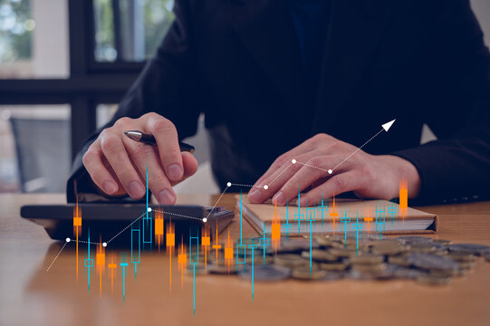 Investment and finance concept, businessman using calculator and stacking coins with virtual chart, stock market, profits and business growth.