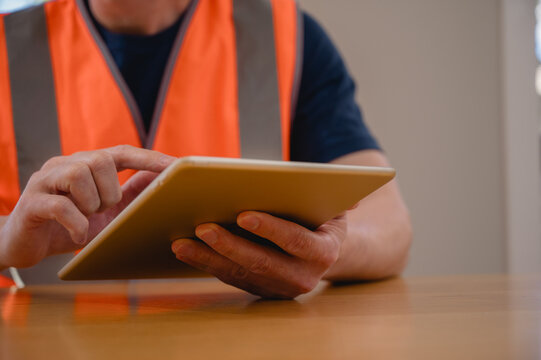 DevOps engineer in Digital transformation technology strategy of business data, optimize and automate operations, customer service management, Engineer wearing vest using tablet working on site.