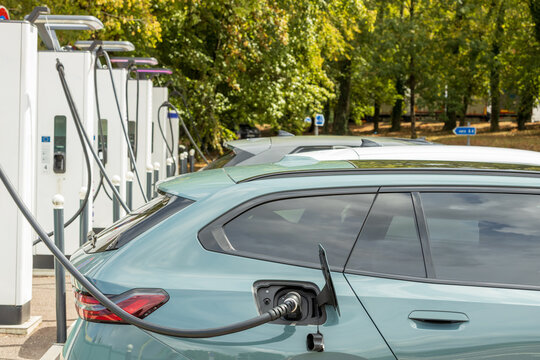 Multiple electric cars charging at highway station with cables connected, symbolizing sustainable transport, eco friendly mobility and modern green energy infrastructure