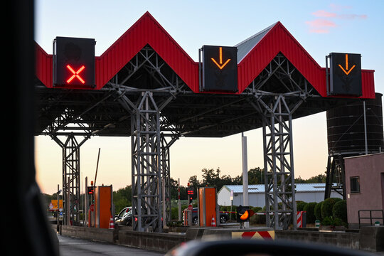 toll booth at sunset with traffic lights directing vehicles on a quiet evening road