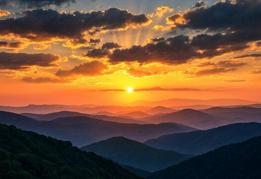 Breathtaking panoramic sunset over rolling mountain ranges with golden light and dramatic clouds