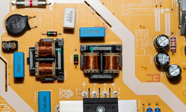 Electronic power supply board with copper coils and capacitors close up