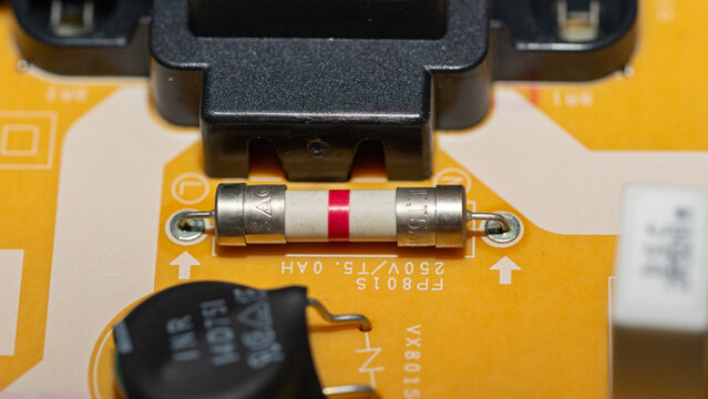 Macro shot of ceramic fuse soldered on yellow circuit board