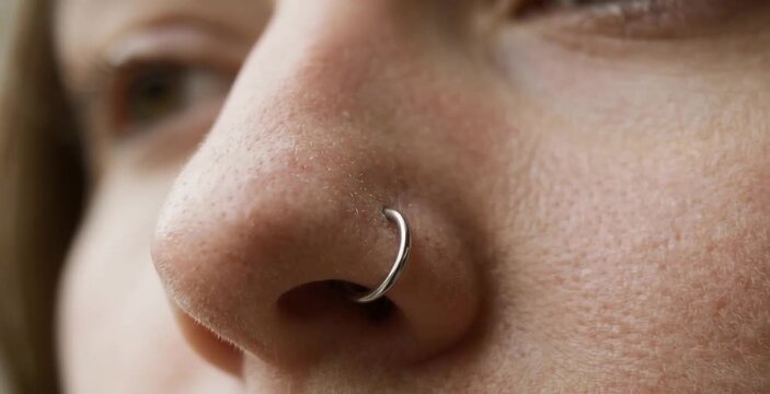 Macro Close Up of Woman Nose with Silver Hoop Nostril Ring Piercing and Natural Skin